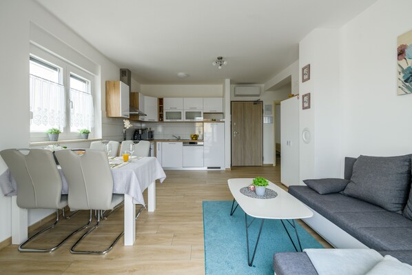 Un appartement moderne comprenant un coin repas, une cuisine et un salon.
