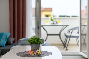 A modern living room with a white coffee table, a potted plant, and a decorative glass bowl.