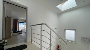 A modern interior with a staircase, a skylight, and a view of a dining area. - Apartment Kate with balcony (Pula)