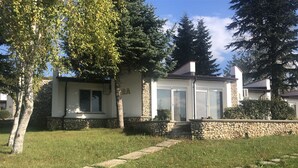 A house with a stone facade, a number '2A' on the wall, and a stone pathway leading to the entrance. - Bultrak- eco village (Balchik)