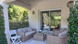A covered patio with wicker furniture, including a sofa, chairs, and a coffee table. - Villa 170 m2 au Calme Avec Piscine 9,60 x 4,60 sur Terrain Paysagé de 3000m2 (Vence)