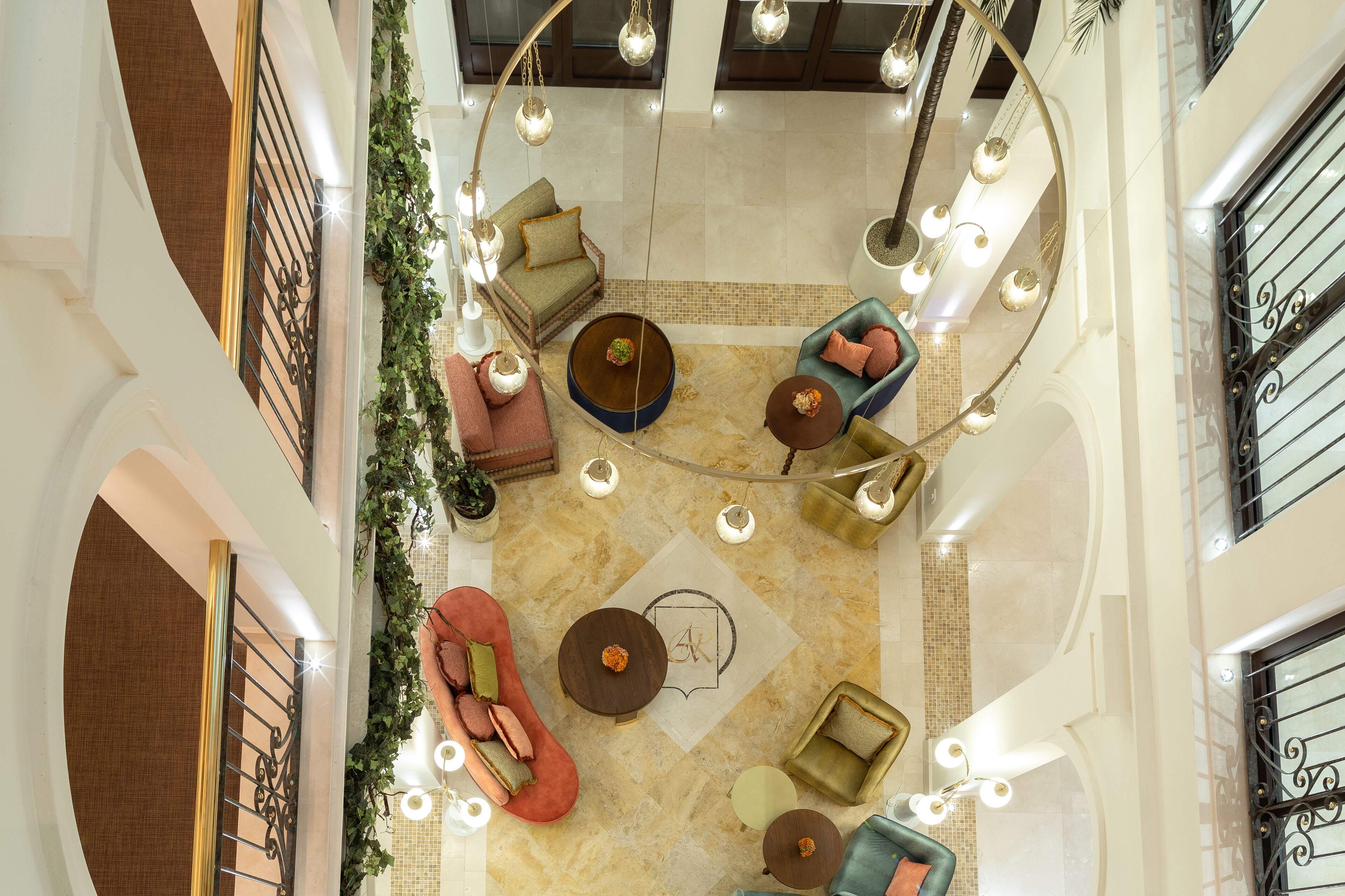 A spacious lobby with multiple seating areas, a central coffee table, and decorative lighting.