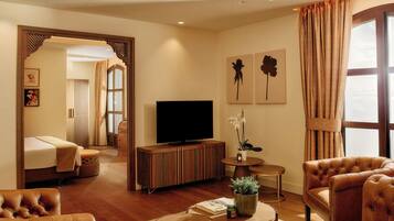Una sala de estar moderna con televisor, sillones de cuero, una mesa de centro y una estantería.