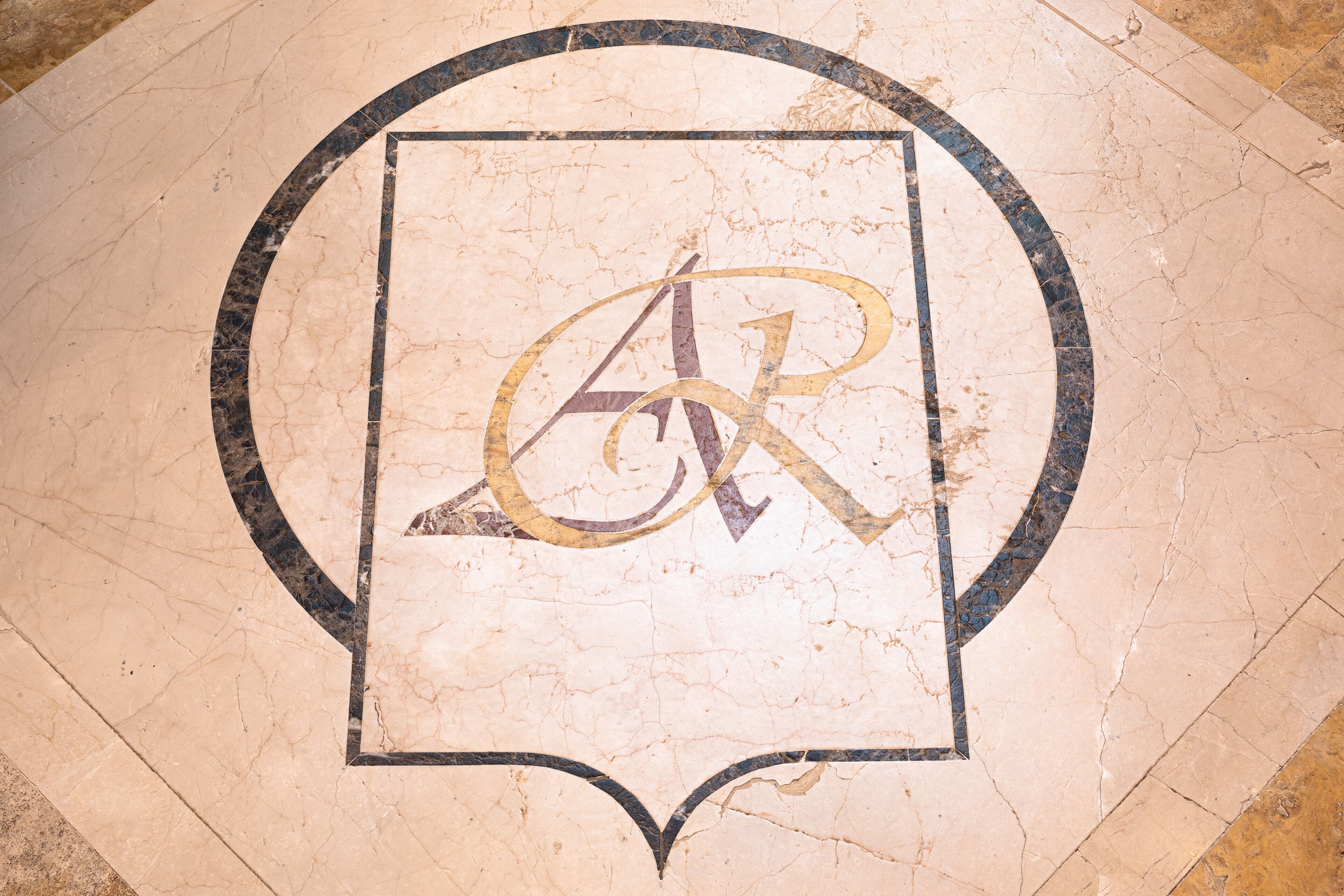 A marble floor with a circular design and a central emblem.