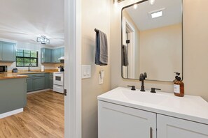 Eine moderne Küche mit hellem Holzboden, turquoise Küchenschränken und einer weißen Arbeitsplatte.