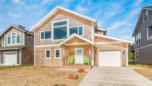 A two-story house with a front porch, a garage, and a driveway.