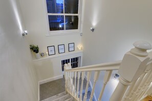 Staircase leads to an upper floor with a view of the surrounding neighborhood.