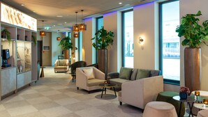 A modern lobby with sofas, a reception desk, and large windows. - Leonardo Hotel Augsburg (Augsburg)