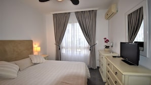 A hotel room with a bed, a television, a dresser, a lamp, and curtains. - Riviera Del Sol Walking Distance to Beach -  Aldea (Mijas Costa)