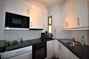 Een koelkast, een microgolfoven, een oven, een broodrooster