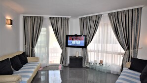 A modern living room with a flat-screen TV, two sofas, a coffee table, and a small side table. - Riviera Del Sol Walking Distance to Beach -  Aldea (Mijas Costa)