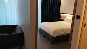 A hotel room with a bed, a nightstand, a desk, and a chair.
