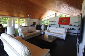 Relax in this inviting living area with two sofas, a dining table, and a large window.