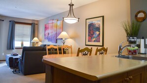 Une cuisine compacte dotée d’un îlot central, d’un coin repas et d’un salon.