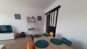 Ein Essbereich mit einem Holztisch, petrolfarbenen Untersetzern und orangefarbenen Stühlen.
