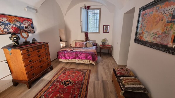 A bedroom with a bed, dresser, and a window. - Beautifully restored romantic apartment in the centre of historic Dolcedo (Dolcedo)