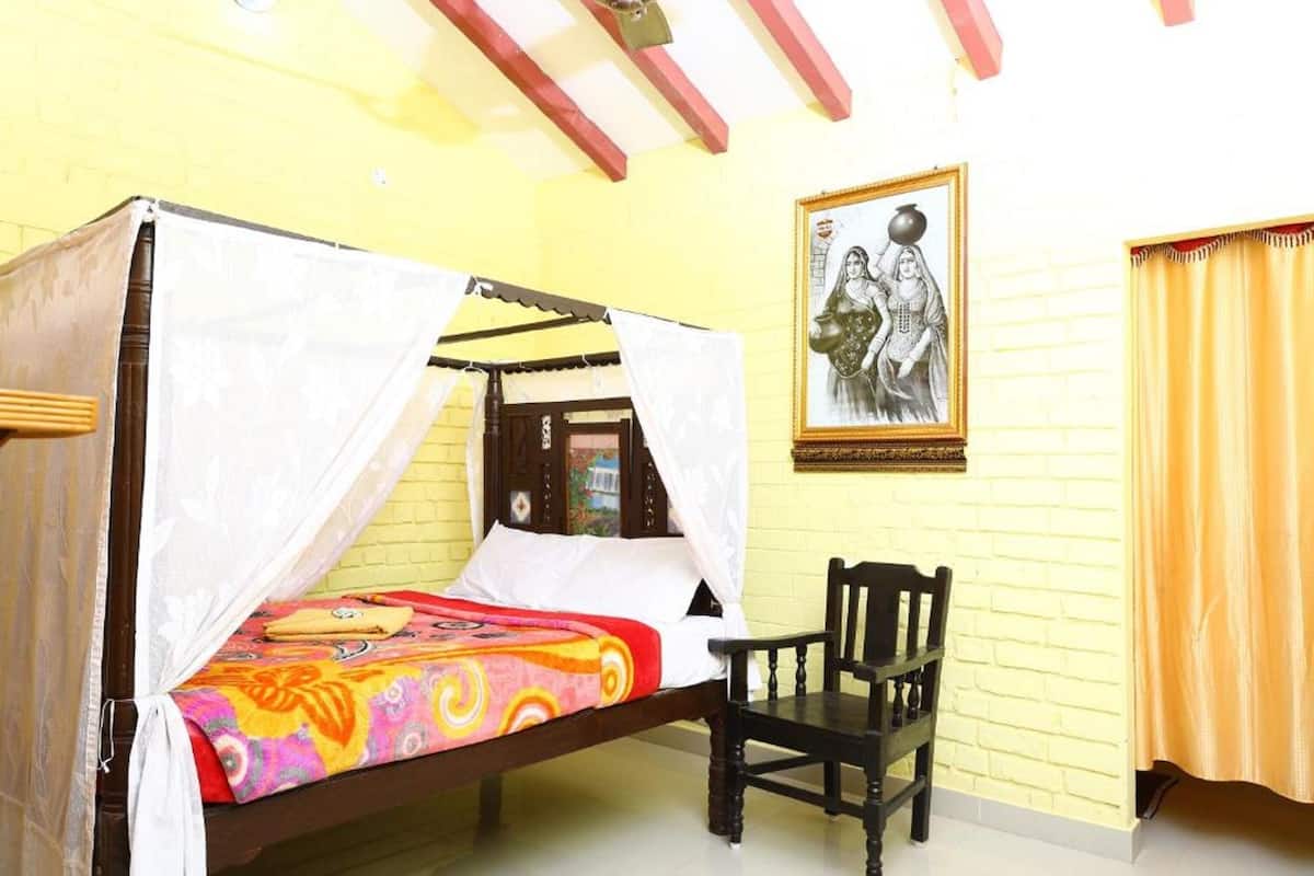 A room with a bed, a chair, a picture on the wall, and a curtain.