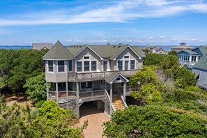 A large, multi-story house with a prominent balcony and a covered porch.
