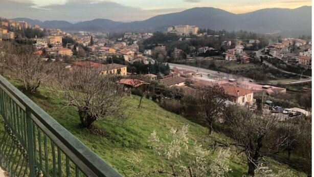 A panoramic view of a town with buildings, a road, and mountains in the background. - Villetta Indipendente Panoramica e Immersa nel Verde (Fiuggi)