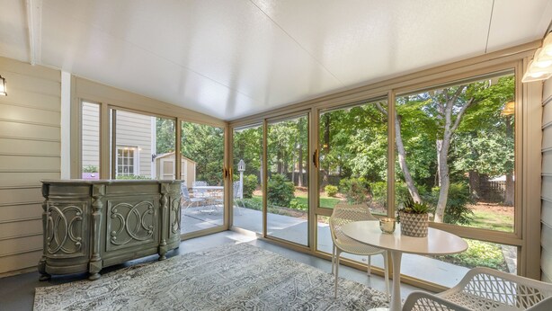 A sunroom with large windows, a dining table, and a decorative cabinet. - Big Beds for Everyone!  Braves Stadium only 2.5 miles away! (Marietta)