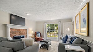 A living room with a fireplace, a sofa, a coffee table, and a television. - Big Beds for Everyone!  Braves Stadium only 2.5 miles away! (Marietta)