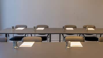 A conference room with a long table, chairs, and glass water pitchers.