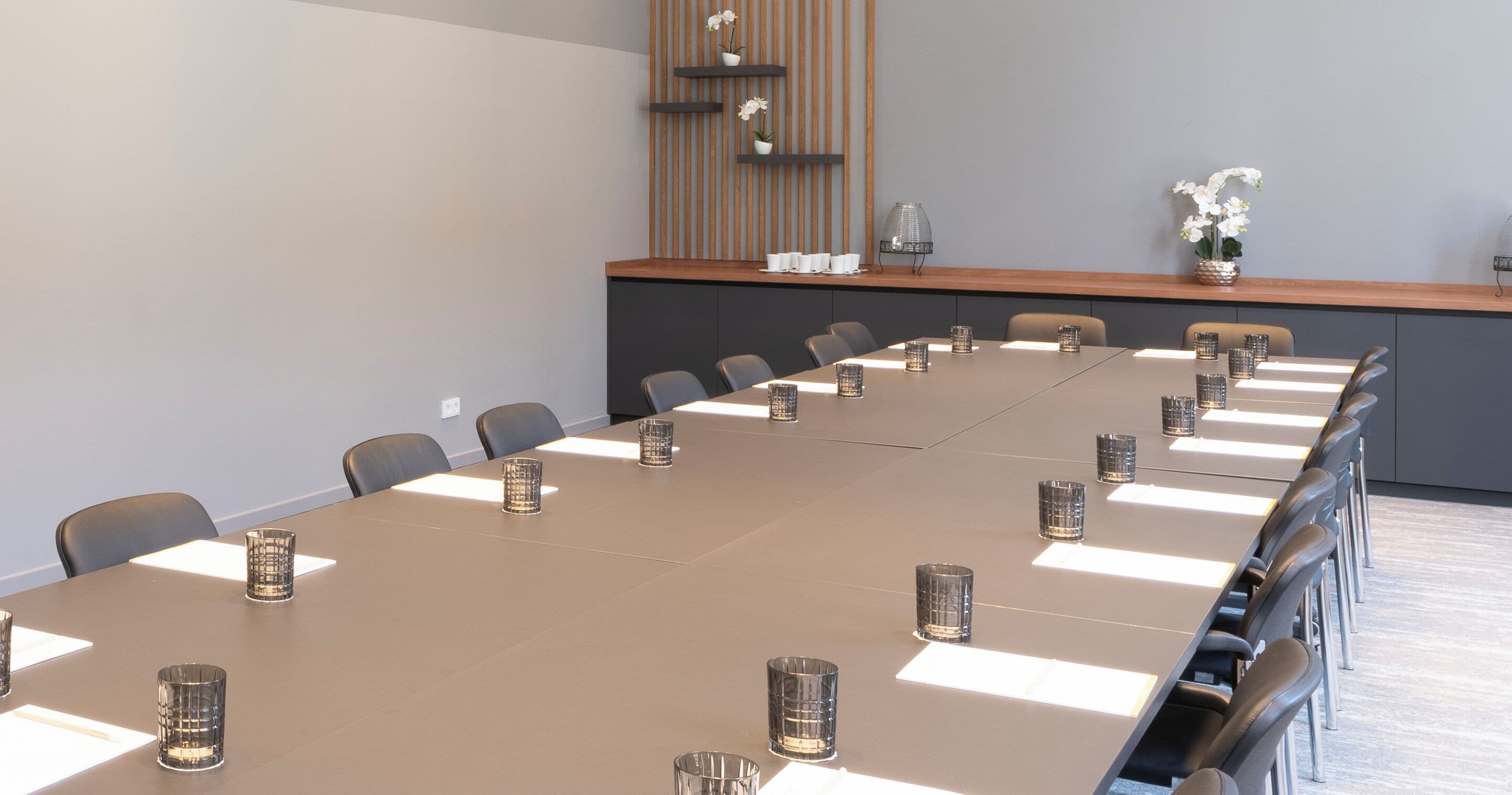 A conference room with a long table, chairs, and decorative items.