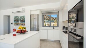 Eine moderne Küche mit weißen Schränken, einem Edelstahlkühlschrank und einem eingebauten Backofen.