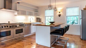 A modern kitchen with a central island, stainless steel appliances, and bar seating. - Historical Bed and breakfast<br> (Water Mill)
