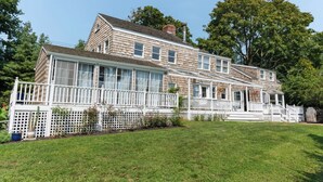 A two-story house with a large porch, white railings, and a fenced garden area. - Historical Bed and breakfast<br> (Water Mill)