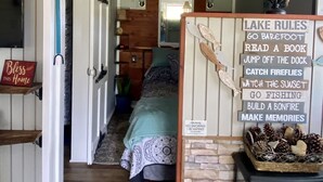 Ein gemütliches Zimmer mit Schlafkoje, einer Holzleiter und einem Schild mit der Aufschrift 'Lake Rules'.