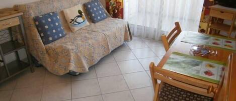 Una sala acogedora con un sofá, una mesa de comedor y sillas.