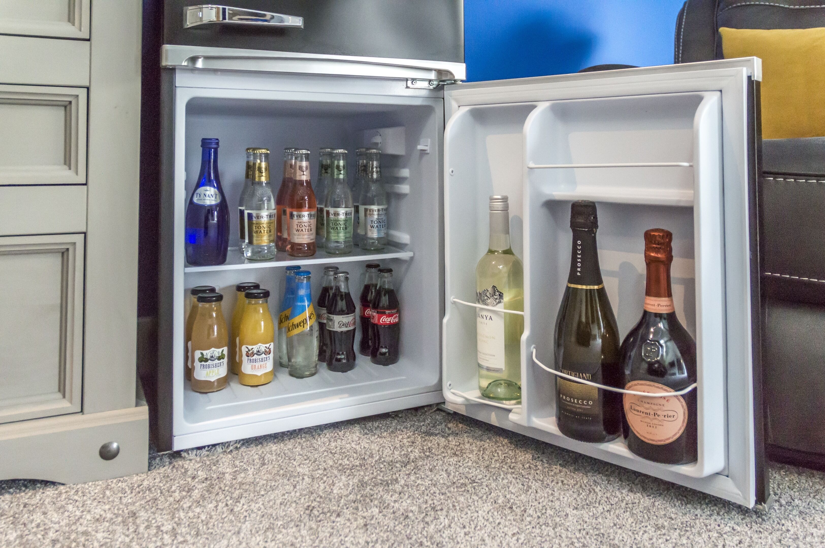 A refrigerator stocked with various beverages including wine, soda, and water.