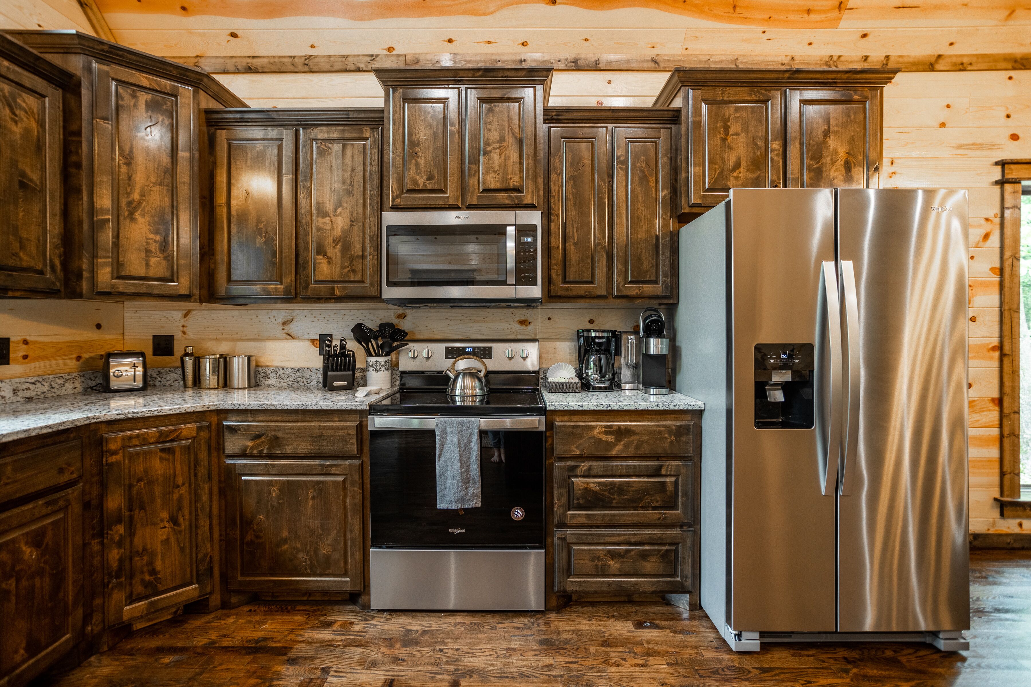 A kitchen with wooden cabinets, stainless steel appliances, and granite countertops.