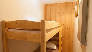 Un letto a castello in una stanza con pareti in legno e una finestra.