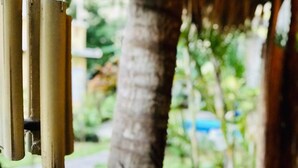 A close-up of a bamboo wind chime hanging outdoors.