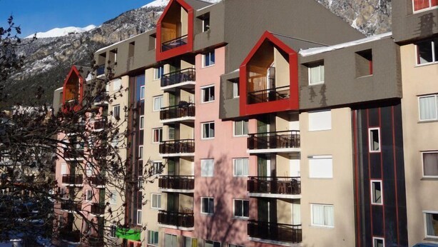 A multi-story hotel with balconies, a mountainous backdrop, and a clear sky. - 200m from resort center, 2nd floor, balcony, tv, ski locker, 31m², Serre Chevalier (Briançon)