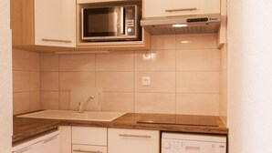 A compact kitchen with a microwave, dishwasher, and wooden countertop. - 200m from resort center, 2nd floor, balcony, tv, ski locker, 31m², Serre Chevalier (Briançon)
