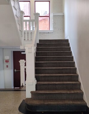 A staircase with a handrail, carpeted steps, and a white railing. - Walk to Nightlife & Attractions (Indianapolis)
