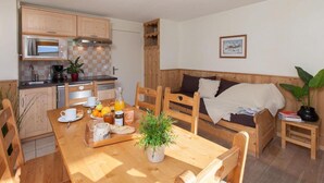 Una cocina acogedora con armarios de madera, un microondas y una mesa de comedor preparada para el desayuno.