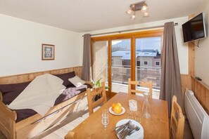 Relax in this inviting room with a sofa, dining table, and flat-screen TV, offering a view of the surrounding cityscape.