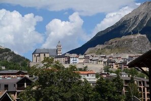 Experience the charm of a traditional mountain town, surrounded by lush greenery and a majestic mountain backdrop.