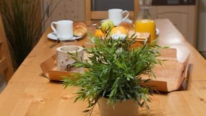 Puisesta ruokapöydästä löytyy aamiaistarvikkeita, ruukussa oleva kasvi ja sydämenmuotoinen koriste.