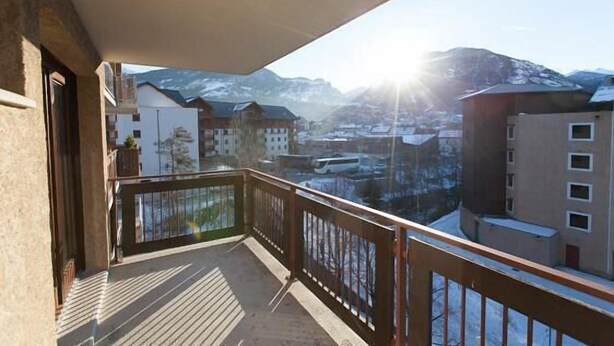 A balcony with a view of snow-covered mountains and buildings. - 200m from resort center, 3rd floor, balcony, tv, ski locker, 25m², Serre Chevalier (Briançon)