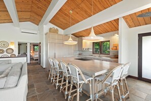 Una cocina amplia con una isla grande, techo de madera e iluminación moderna.