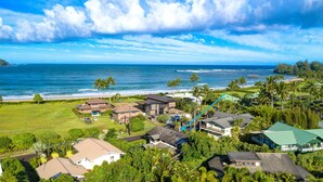 A coastal residential area with houses, a golf course, and a view of the ocean.