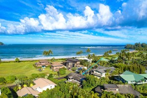 A coastal residential area with houses, a golf course, and a view of the ocean.