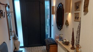 A cozy living room with a sofa, a coffee table, and a fireplace. There is a door leading to another room and a window with blinds. - Apartment in a quiet location, in the middle of orchards on the outskirts of St.Tönis (Tönisvorst)