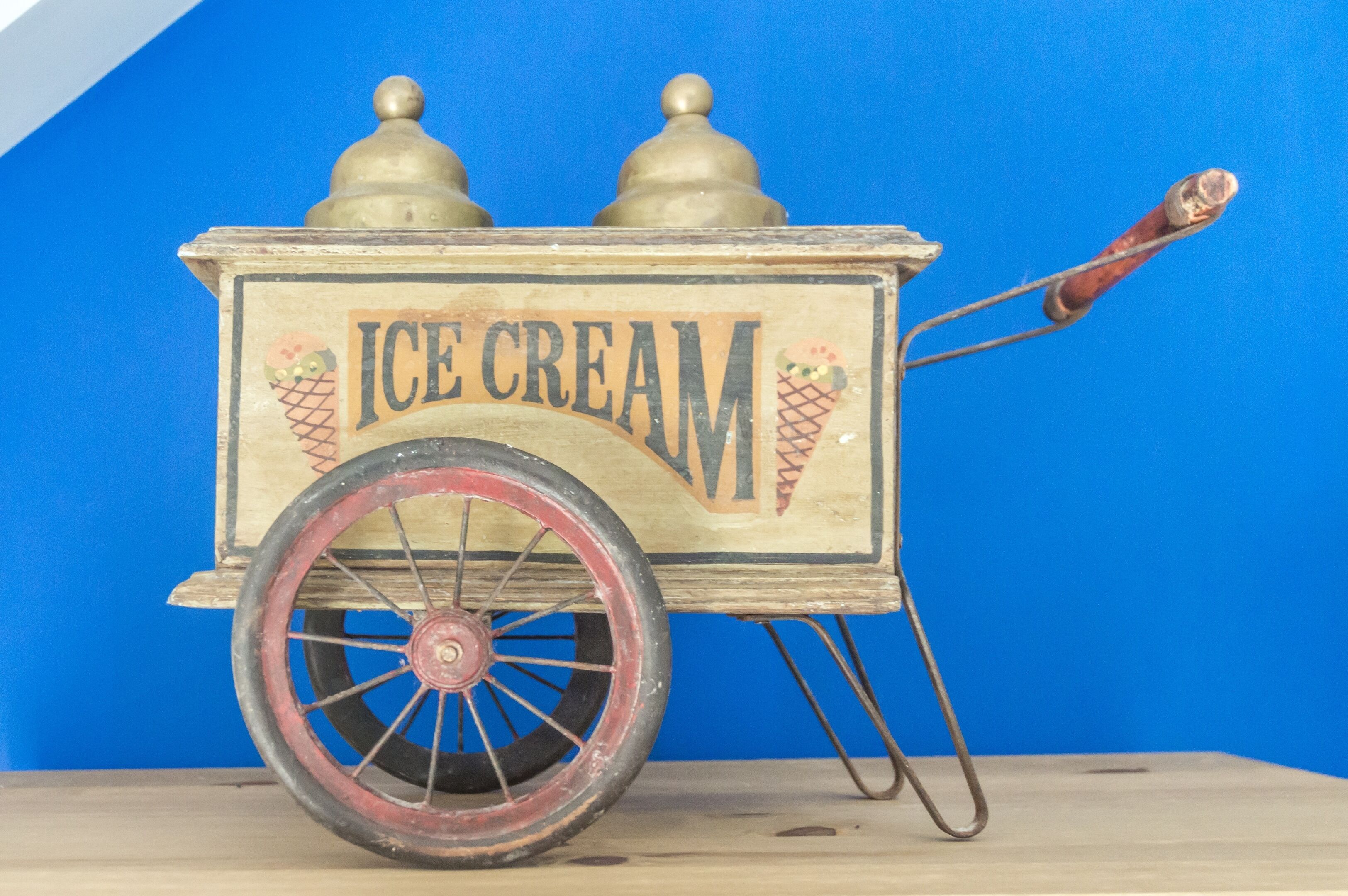 Un chariot à glaces d’époque, doté de deux couvercles en forme de dôme et d’une seule poignée.