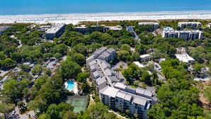 An aerial view of a resort with multiple buildings, a pool, and a beach in the background. - Sunny Coastal Villa| Private Decks, Pool, Tennis | Near Dining & Scenic Grounds (Hilton Head Island)